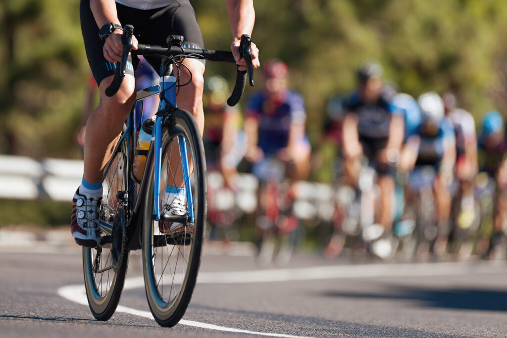 Ciclista en una carrera con pelotón detrás
