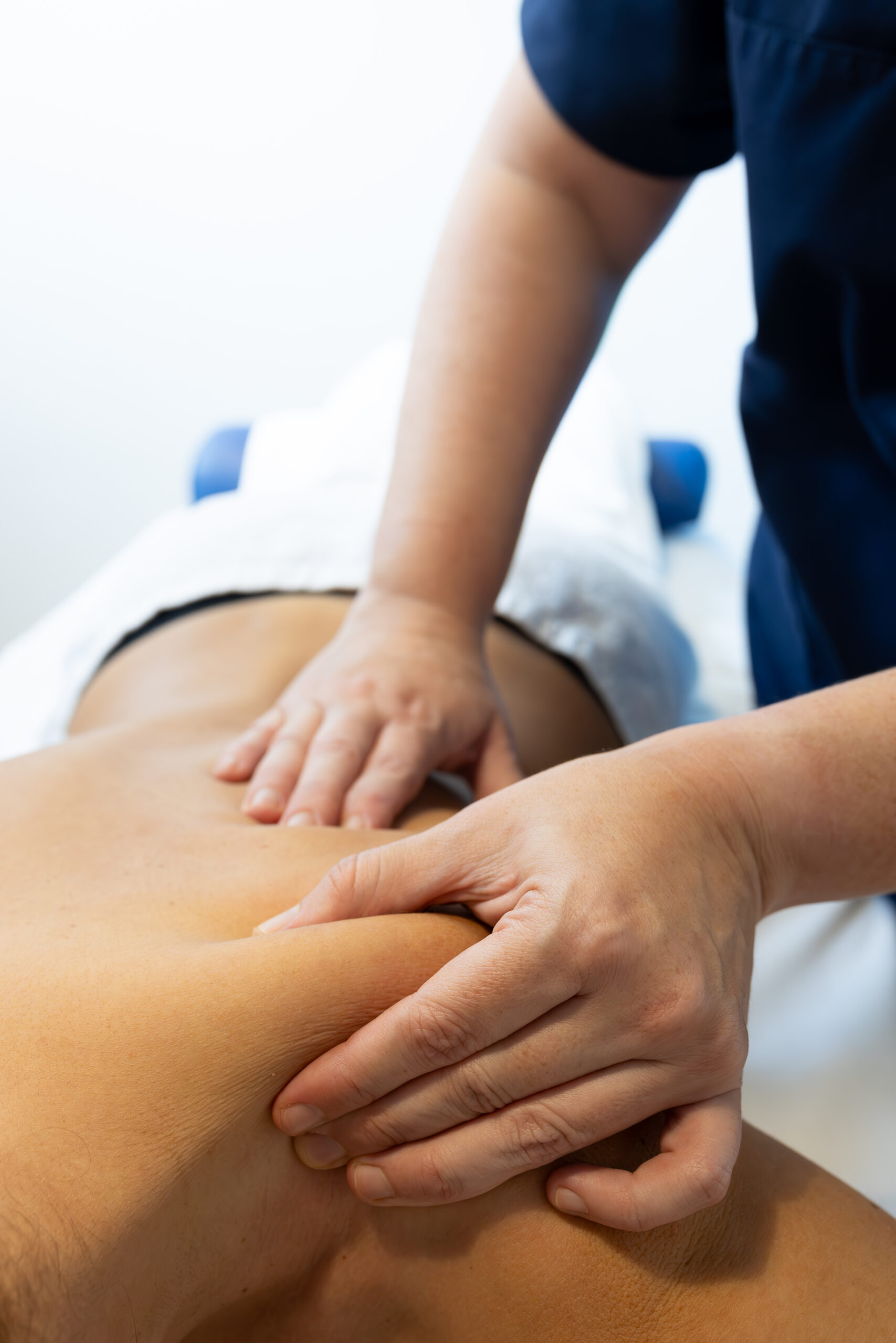 fisioterapeuta realizando un masaje en una paciente, primer plano de sus manos